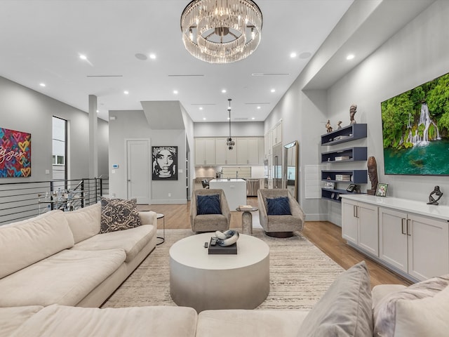 living room with a notable chandelier and light hardwood / wood-style flooring