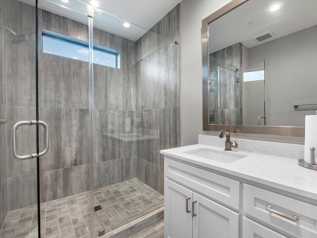 bathroom with walk in shower and vanity