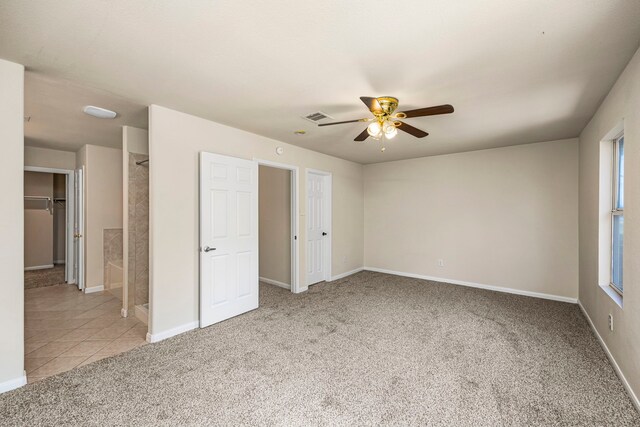 unfurnished bedroom with ceiling fan, light carpet, and ensuite bathroom