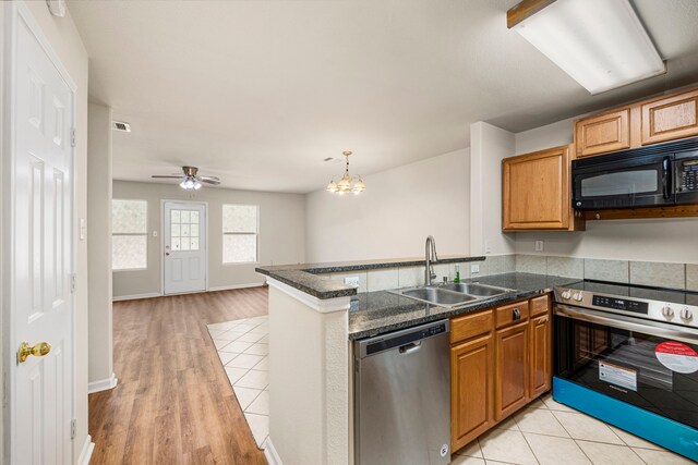 kitchen featuring kitchen peninsula, appliances with stainless steel finishes, decorative light fixtures, ceiling fan with notable chandelier, and sink