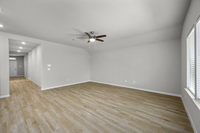 spare room featuring ceiling fan, plenty of natural light, lofted ceiling, and light hardwood / wood-style floors