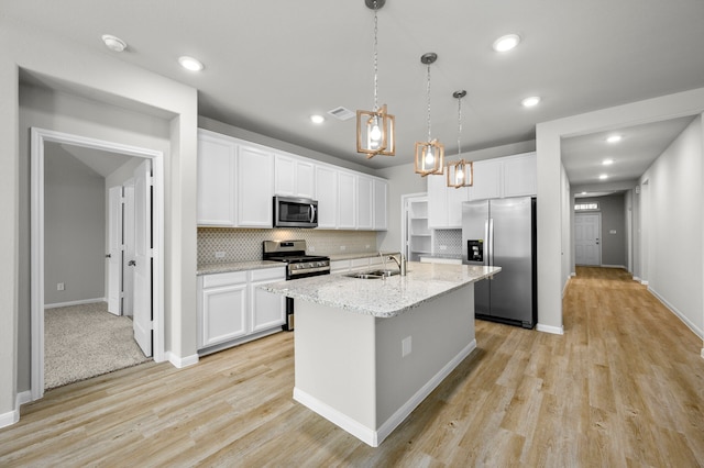 kitchen featuring appliances with stainless steel finishes, white cabinets, light carpet, sink, and tasteful backsplash