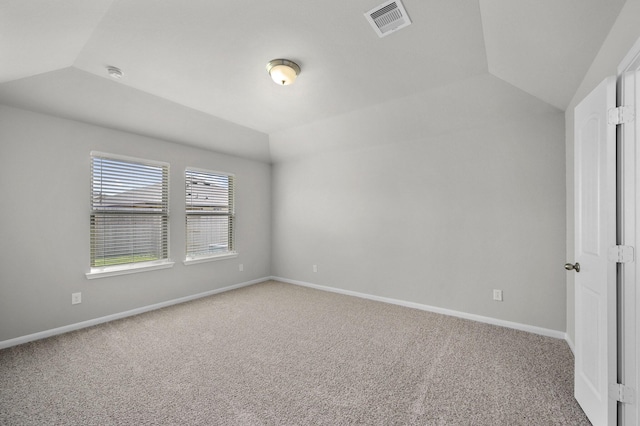 empty room with carpet floors and vaulted ceiling