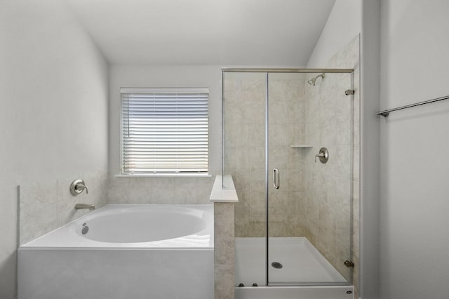 bathroom featuring shower with separate bathtub