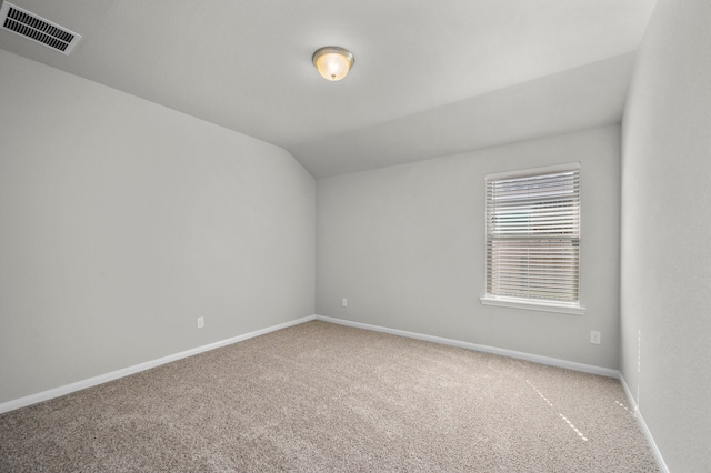 unfurnished room with vaulted ceiling and carpet