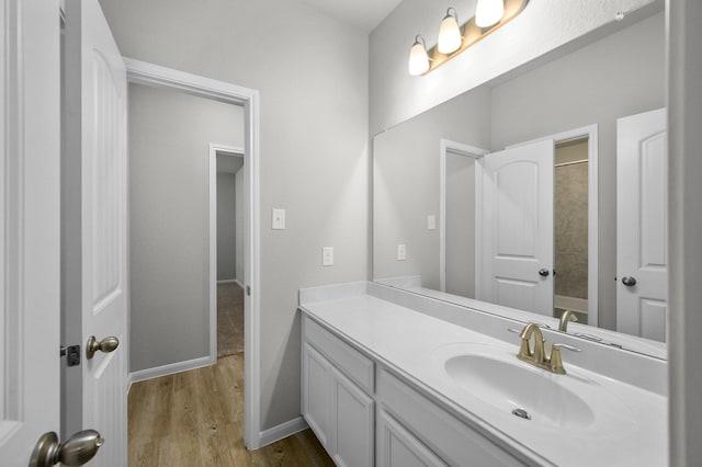 bathroom with hardwood / wood-style flooring, vanity, and shower / bathtub combination