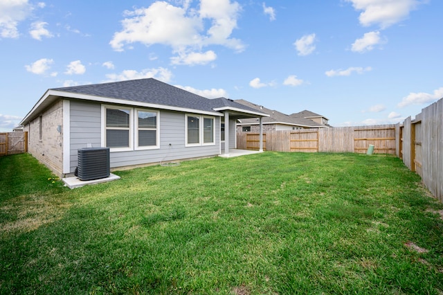 rear view of house featuring central AC and a yard