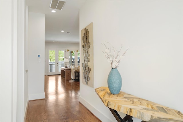 corridor with french doors and hardwood / wood-style flooring