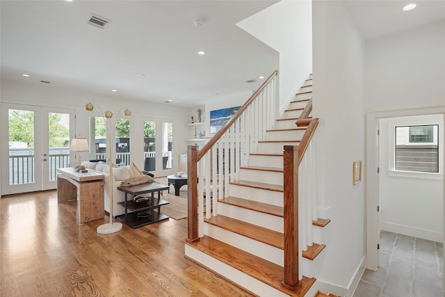 stairway featuring french doors and hardwood / wood-style floors