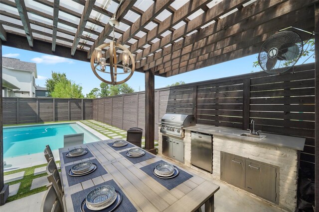 view of patio featuring a fenced in pool, an outdoor kitchen, a pergola, sink, and a grill