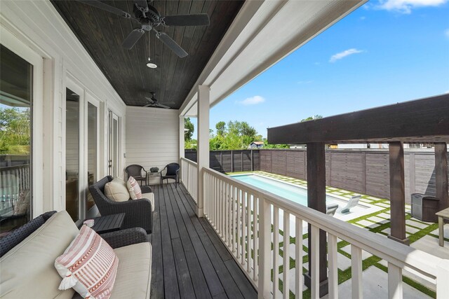 deck with ceiling fan and a fenced in pool