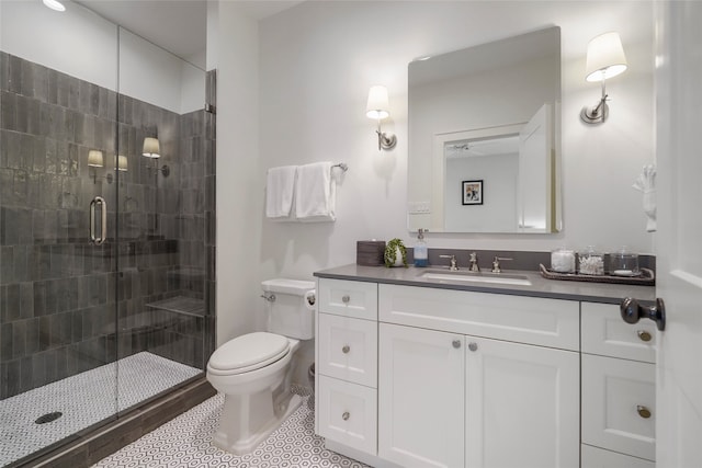 bathroom with vanity, toilet, and a shower with door