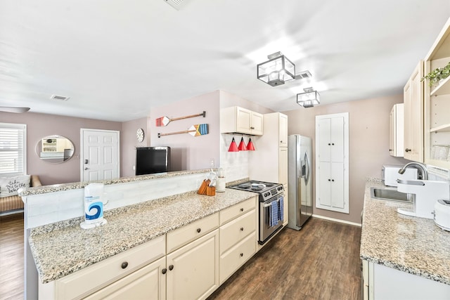 kitchen featuring dark wood-type flooring, cream cabinetry, and stainless steel appliances