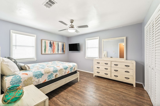 bedroom featuring ceiling fan, a closet, and dark wood-type flooring