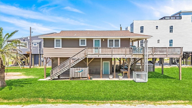 rear view of house with a deck, a yard, stairway, and roof with shingles