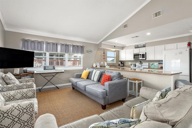 living area with lofted ceiling, baseboards, visible vents, and crown molding