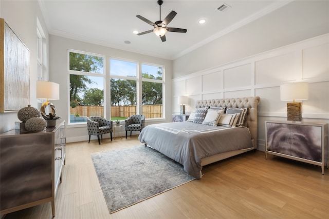 bedroom featuring ornamental molding, ceiling fan, and light hardwood / wood-style flooring