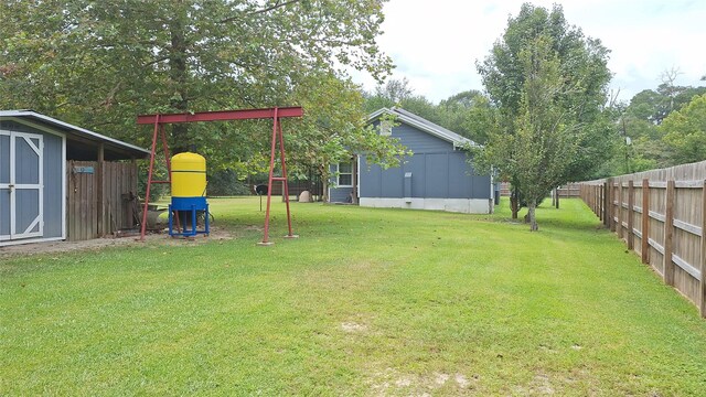 view of yard with a playground and a storage unit