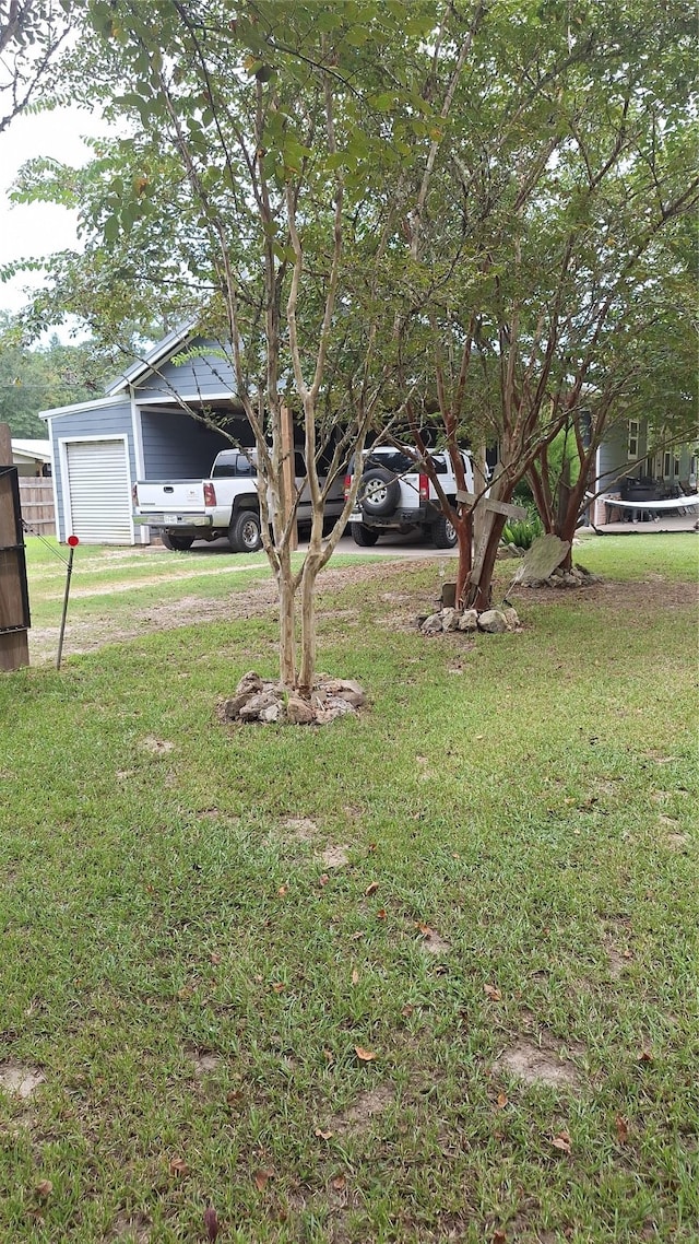 view of yard featuring a garage and an outdoor structure