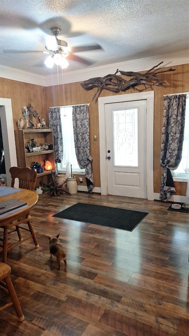 foyer with ceiling fan, wood-type flooring, a textured ceiling, and ornamental molding