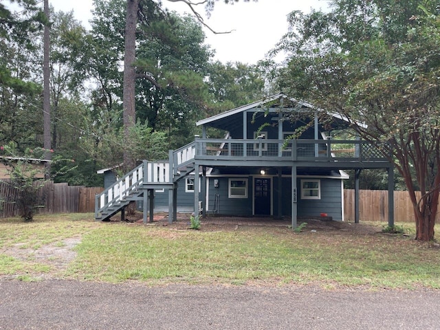 view of property featuring a deck and a front yard