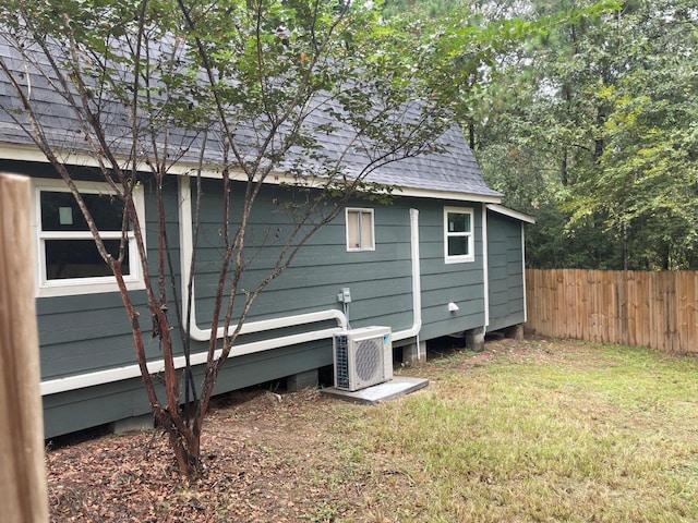 view of side of home with a lawn and ac unit