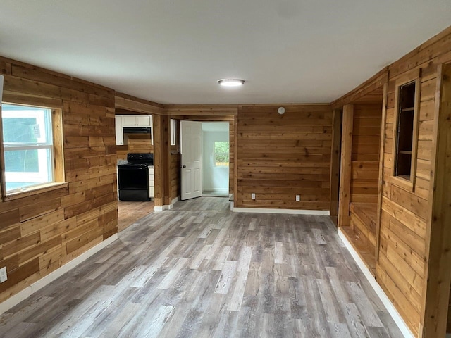 unfurnished living room featuring hardwood / wood-style floors and wood walls