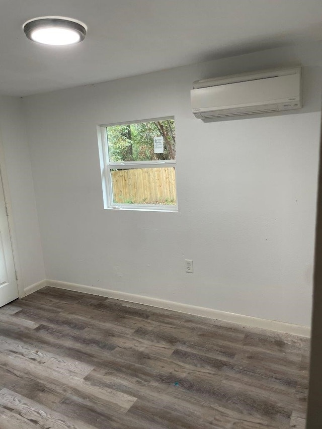 empty room with an AC wall unit and dark hardwood / wood-style floors