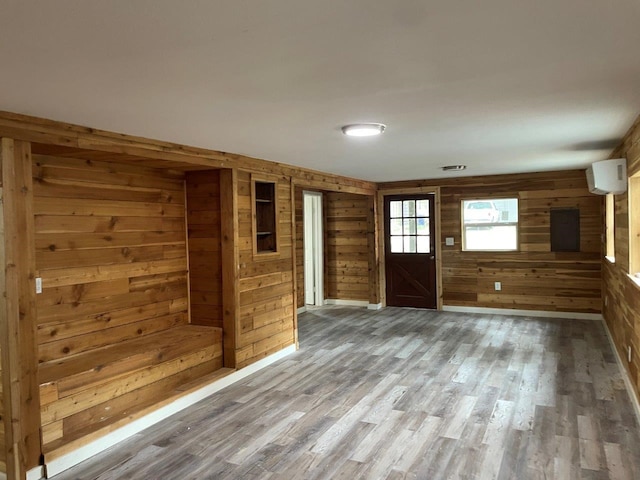 unfurnished room with hardwood / wood-style flooring and wooden walls