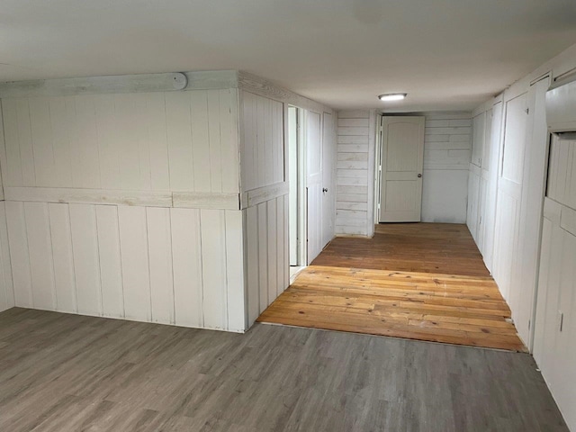 hallway featuring hardwood / wood-style flooring and wooden walls