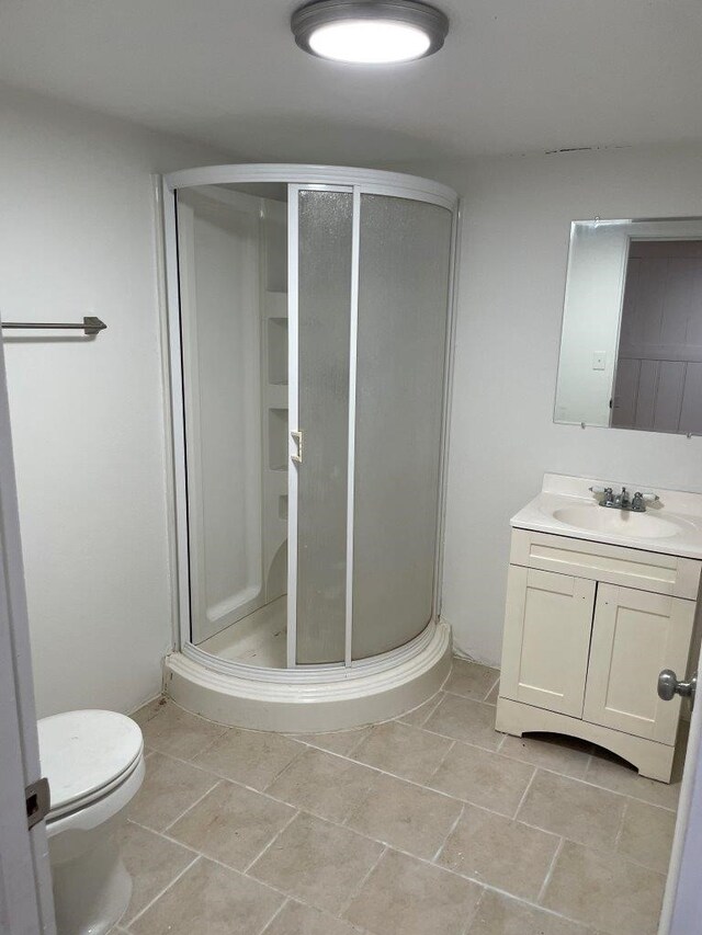 bathroom with a shower with shower door, toilet, and vanity