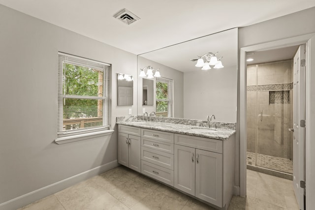 bathroom with vanity, tile patterned flooring, a notable chandelier, and a shower with door