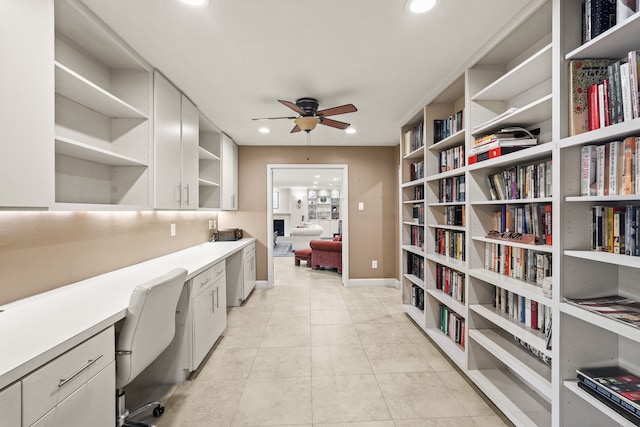 home office featuring built in desk, ceiling fan, and light tile patterned flooring