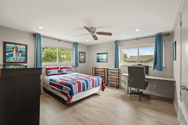 bedroom with multiple windows, ceiling fan, and light hardwood / wood-style floors