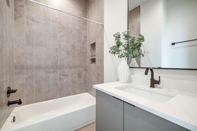 bathroom with tiled shower / bath and vanity