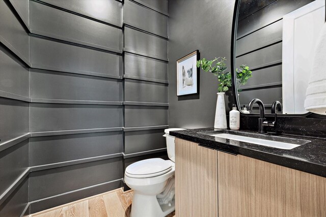 bathroom with vanity, toilet, and hardwood / wood-style flooring