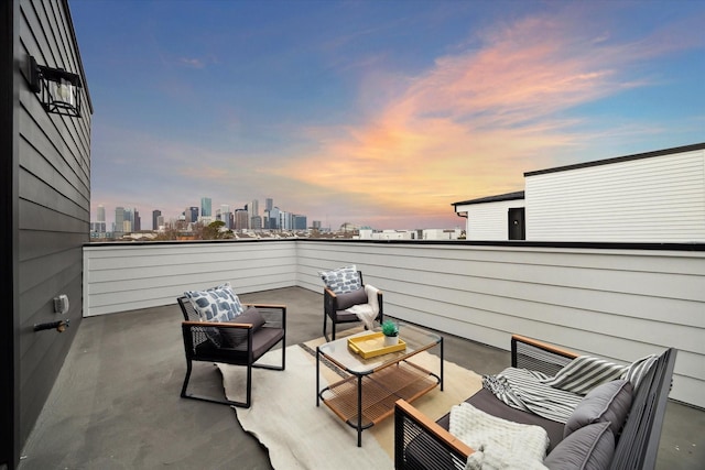 patio terrace at dusk featuring a balcony and an outdoor living space