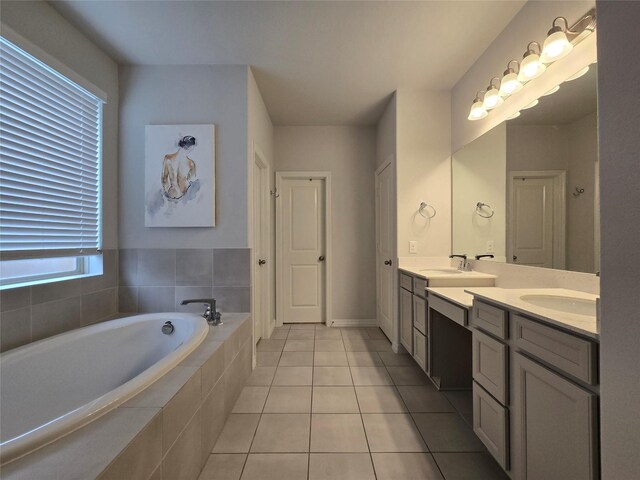 bathroom with tiled tub, vanity, and tile patterned floors