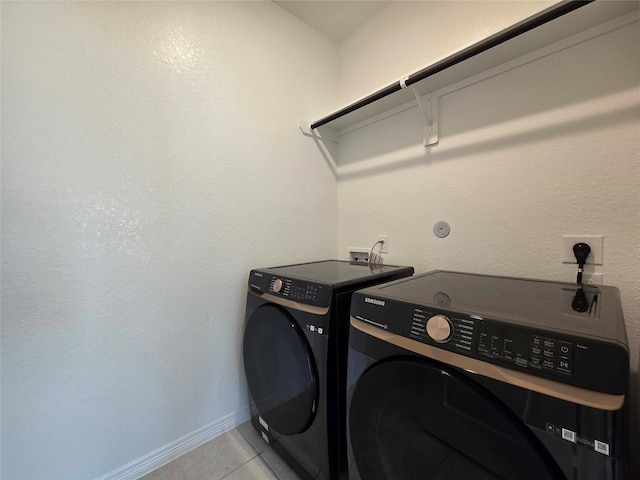 washroom featuring light tile patterned flooring and washer and dryer