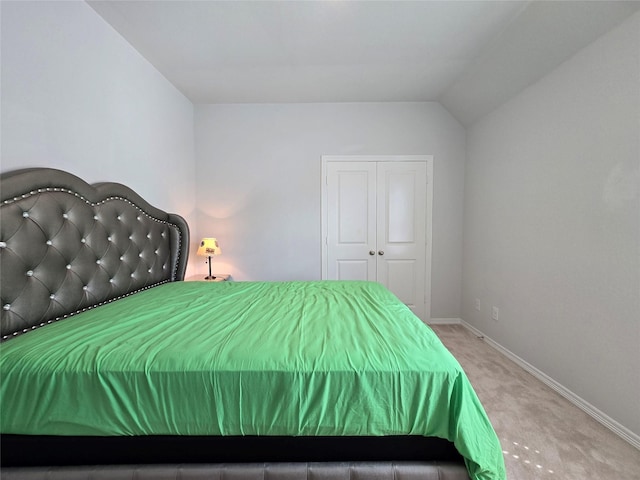 bedroom featuring lofted ceiling, carpet flooring, and a closet