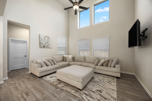 living room featuring hardwood / wood-style floors, a high ceiling, and ceiling fan