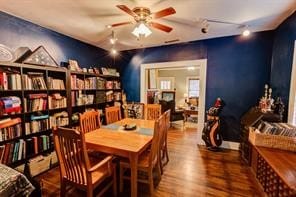 dining area featuring rail lighting and hardwood / wood-style flooring