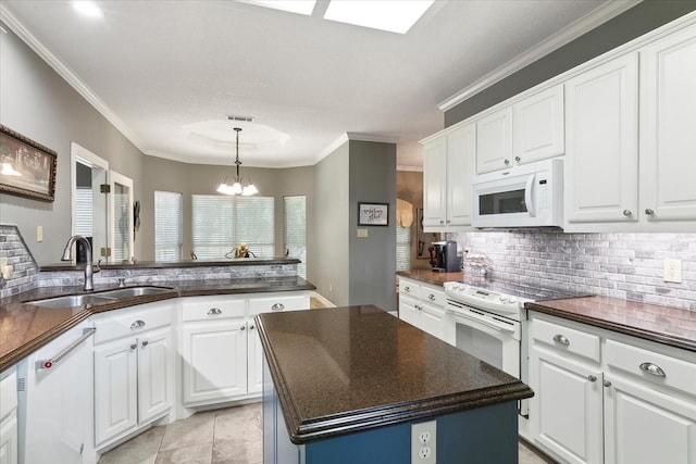 kitchen featuring sink, white appliances, a kitchen island, and decorative backsplash