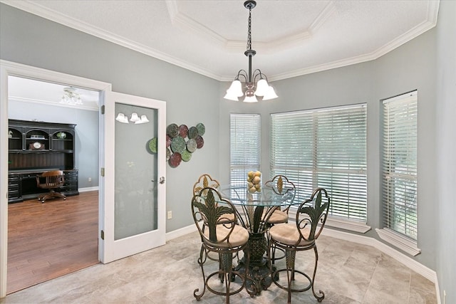 tiled dining area with a notable chandelier, a tray ceiling, and crown molding