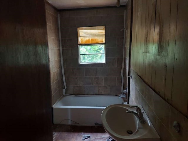 bathroom with wood walls and tiled shower / bath