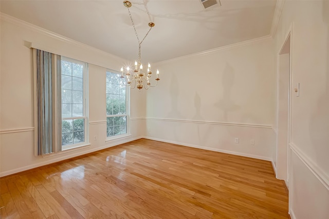 unfurnished dining area featuring a healthy amount of sunlight, ornamental molding, light hardwood / wood-style flooring, and an inviting chandelier