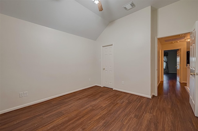 spare room featuring ceiling fan, dark wood-type flooring, and vaulted ceiling