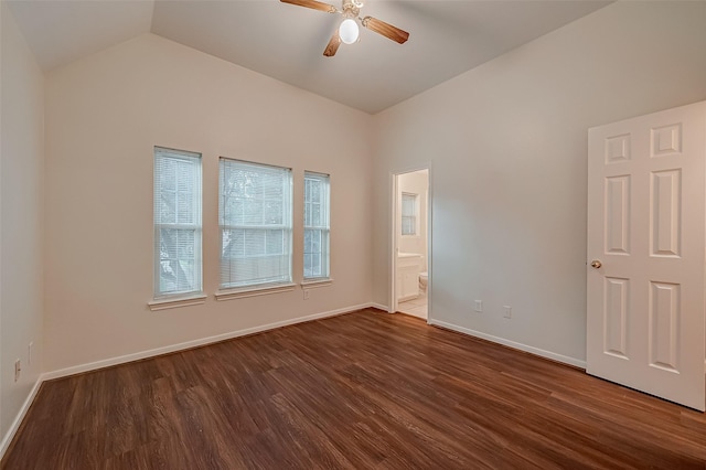 spare room with ceiling fan, dark wood-type flooring, and vaulted ceiling