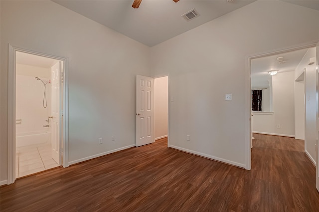 unfurnished bedroom featuring connected bathroom, ceiling fan, and dark wood-type flooring