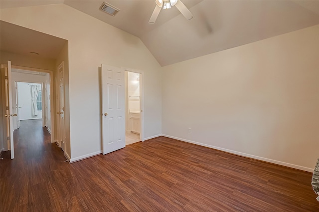 unfurnished bedroom featuring vaulted ceiling, connected bathroom, ceiling fan, and dark hardwood / wood-style floors